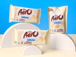 Nestlé unveils new Aero Milkybar range Packs of Aero Milkybar and Aero Milkybar Buttons are stacked on semi-circle shapes against a blue background with a white table.