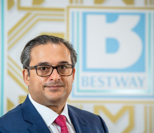 Bestway Wholesale announces new managing director Dawood Pervez, chairman of Bestway Limited, stands in front of the Bestway logo.