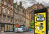 Hooch unveils “no-nonsense” multi-media campaign An image of a street in Edinburgh with Edinburgh Castle in the skyline. The Hooch summer 2026 campaign is on the digital screen in the foreground.