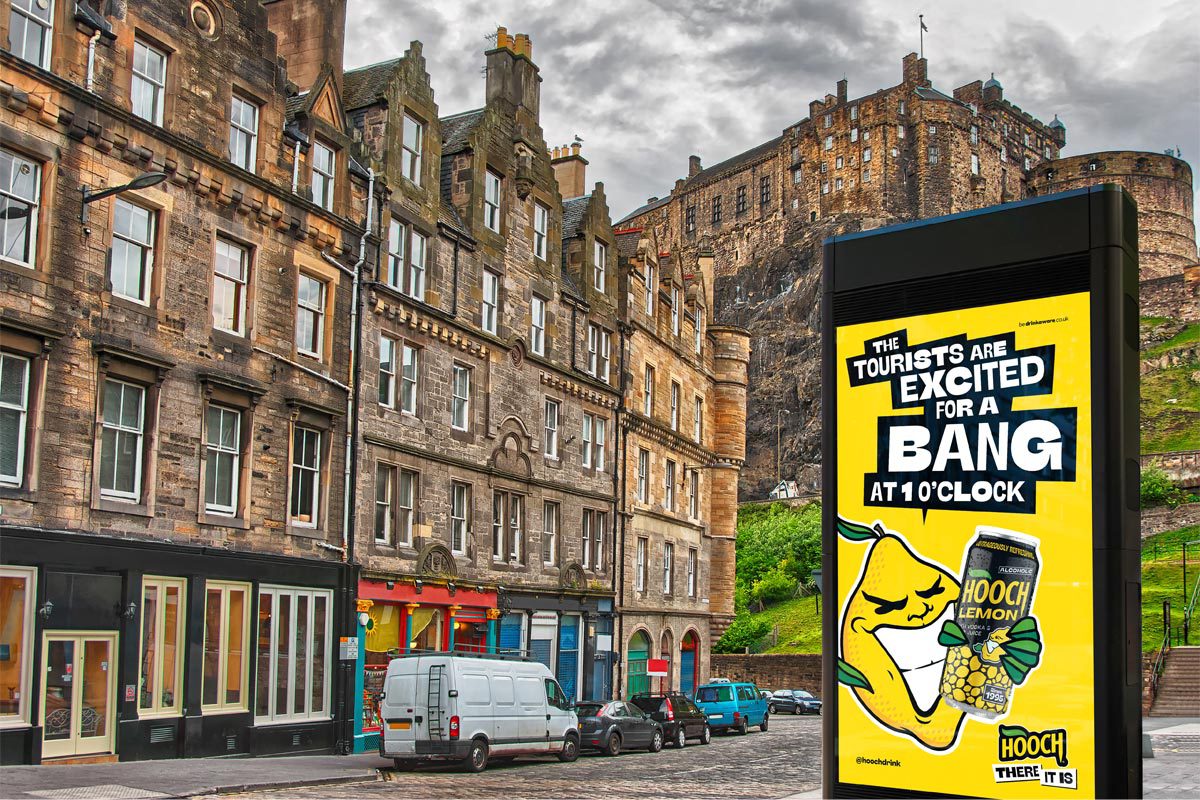 An image of a street in Edinburgh with Edinburgh Castle in the skyline. The Hooch summer 2026 campaign is on the digital screen in the foreground.