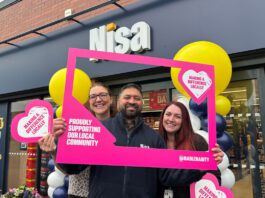Co-op hits £20million milestone on charity donations A group of people stand outside a Nisa store with a Making a Difference Locally banner around them.