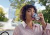 Pepsi launches summer campaign for ice cream flavours A woman sits drinking from a can of Pepsi Cherry & Vanilla Flavour in a park.