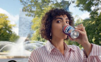 Pepsi launches summer campaign for ice cream flavours A woman sits drinking from a can of Pepsi Cherry & Vanilla Flavour in a park.