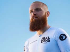 Bulldog marks sponsorship of IronMan with Russ Cook Endurance athlete Russ Cook stands against a blue background wearing a Bulldog Skincare branded top.