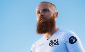 Bulldog marks sponsorship of IronMan with Russ Cook Endurance athlete Russ Cook stands against a blue background wearing a Bulldog Skincare branded top.