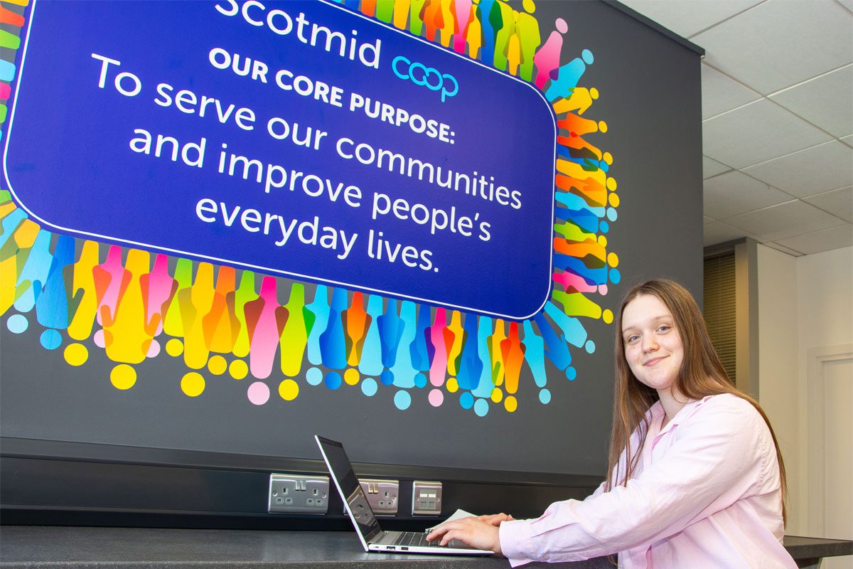 Anna Lodge, Saltire Scholar, sits with a laptop in Scotmid HQ.