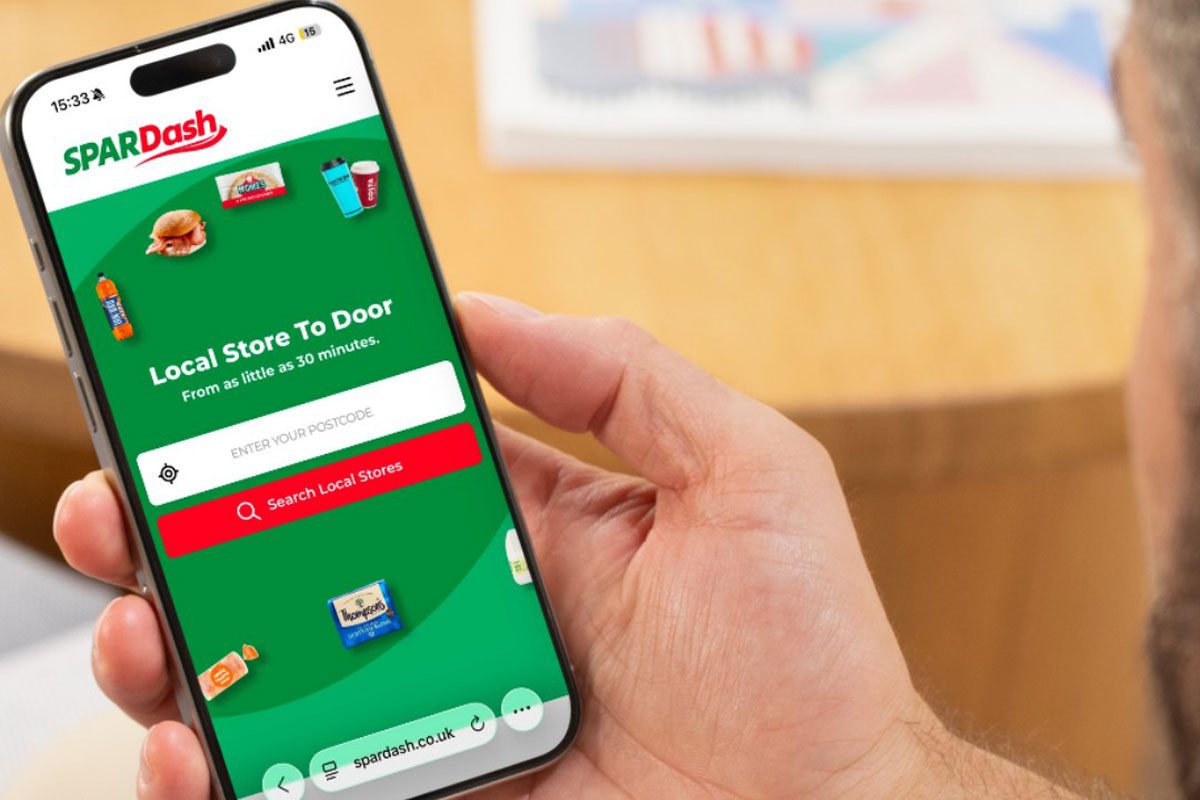 A person holds a mobile phone with the Spar Dash app open on it.