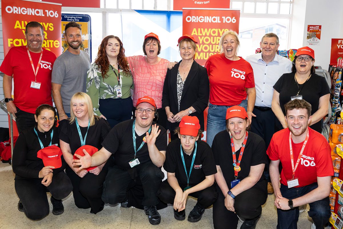 A group of people stand in Spar Kincorth for a live broadcast of Original 106 Breakfast Show.