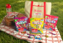 Swizzels launches Day Out With The Kids promo packs A picnic scene with variety packs of Swizzels sweets, a picnic blanket, a basket, sunglasses, a water bottle and an insulated bag with the Swizzels and Day Out With The Kids logo on the front of it.