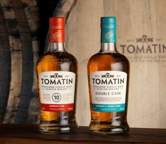 Tomatin expands listings across Booker locations Bottles of Tomatin 10 Year Old whisky and Tomatin Double Cask whisky stand in front of a wooden barrel with the Tomatin logo on it.
