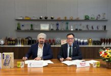Asco Foods gains distribution for Vitasoy Representatives from Asco Foods and Vitasoy sit at a table signing a new distribution deal between the two firms.