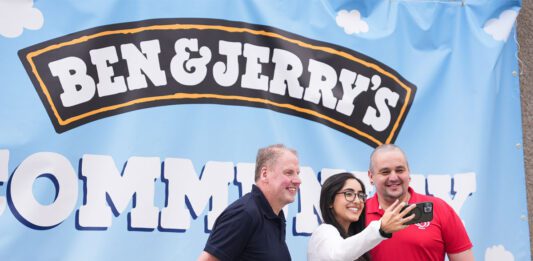 Chris Cobb wins UK-wide Ben & Jerry’s competition Chris Cobb, store owner of Cults Stores – KeyStore, stands with Ghayda Jameel, senior account exec at Cirkle, and Andrew Young, business development exec at The Magnum Ice Cream Company, stand together to take a selfie in front of the Ben & Jerry's Community Picnic banner.