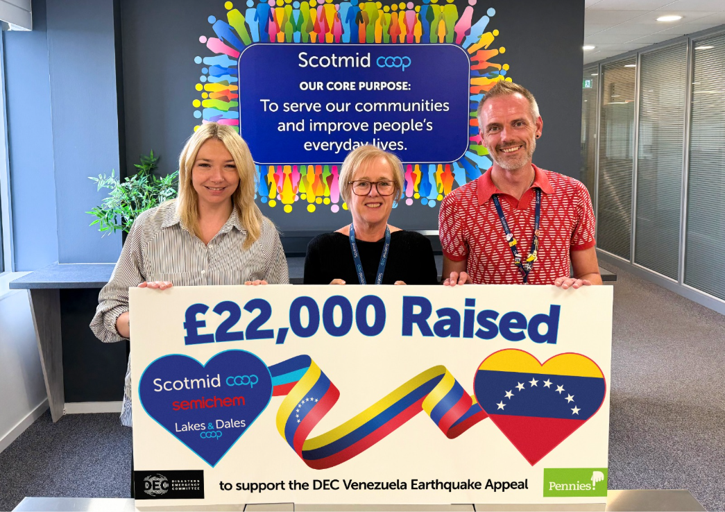 Team members from Scotmid Co-op stands holding a banner highlighting a £22,000 donation from Scotimd to the Disasters Emergency Committee Venezuela Earthquake Appeal.