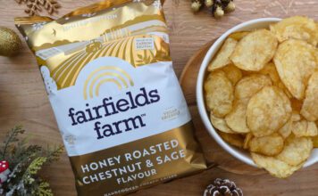 Fairfields Farm brings back popular Christmas crisps A pack of Fairfields Farm Honey Roasted Chestnut & Sage crisps sits next to a bowl with crisps in it with some Christmas decorations around the two.