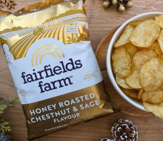 Fairfields Farm brings back popular Christmas crisps A pack of Fairfields Farm Honey Roasted Chestnut & Sage crisps sits next to a bowl with crisps in it with some Christmas decorations around the two.