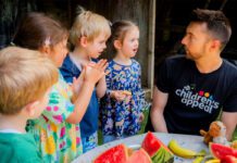 Kellogg’s teams up with STV’s Big Scottish Breakfast STV presenter Sean Batty sits at a table with fruit on it talking to a group of children.