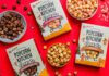 Popcorn Kitchen unveils Christmas gifting range Packs of Popcorn Kitchen Christmas gift packs lie across a red tabletop with bowls of the popcorn around them. The flavorus include White Choc & Raspberry, Double Choc Caramel Cookie and Gingerbread.