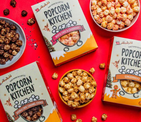 Popcorn Kitchen unveils Christmas gifting range Packs of Popcorn Kitchen Christmas gift packs lie across a red tabletop with bowls of the popcorn around them. The flavorus include White Choc & Raspberry, Double Choc Caramel Cookie and Gingerbread.