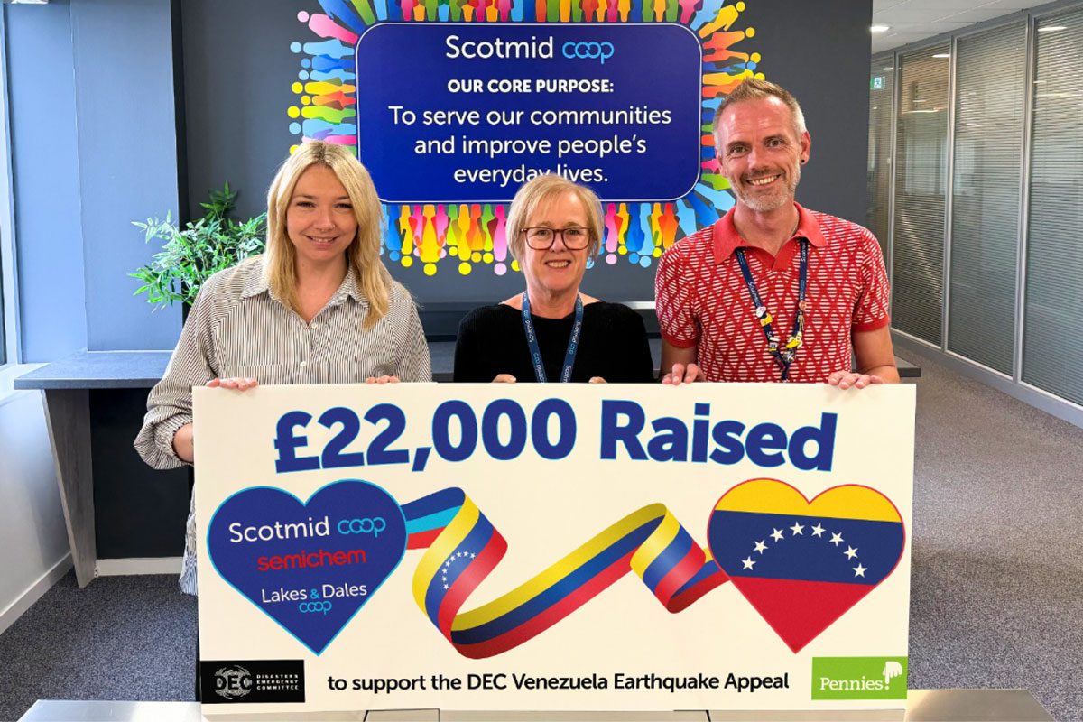 Team members from Scotmid Co-op stands holding a banner highlighting a £22,000 donation from Scotimd to the Disasters Emergency Committee Venezuela Earthquake Appeal.