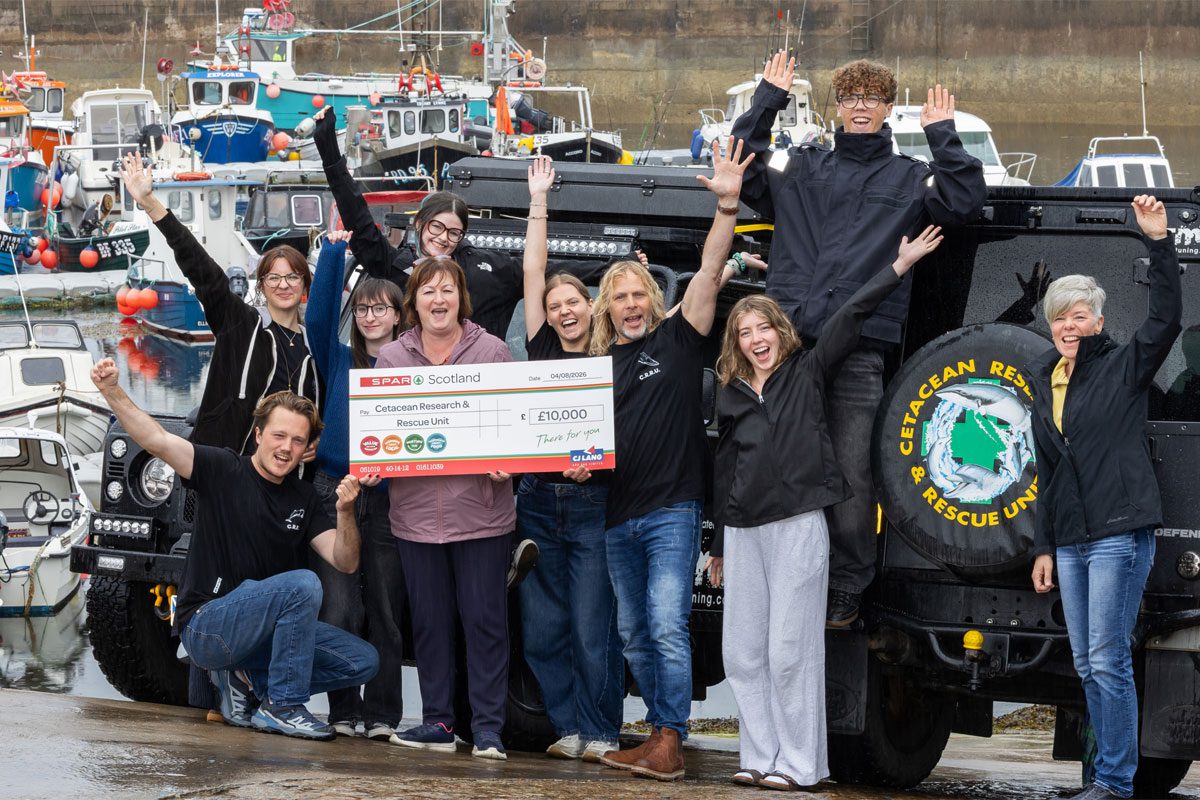 Paula Middleton, head of marketing at CJ Lang & Son, stands with the Cetacean Research & Rescue Unit holding a cheque for £10,000.