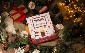 Walker’s Shortbread Advent Calendar returns for 2026 A Walker's Shortbread Advent Calendar sits in the middle of a Christmas scene with presents, decorations and lights.