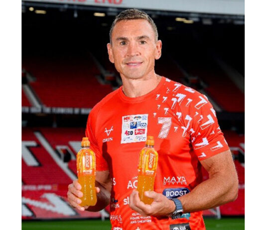 Boost announces sponsorship of Sinfield’s 7-in-7 fundraiser Sir Kevin Sinfield stands holding bottles of Boost Sport drinks while standing in Old Trafford stadium.