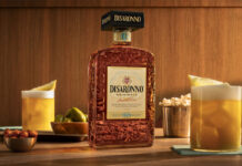 Disaronno unveils new bottle design A bottle of the 2026 redesign for Disaronno stands on a table with Amaretto Sour cocktail serves around it as well as bowls of nibbles.