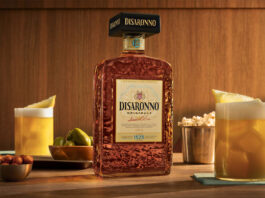 Disaronno unveils new bottle design A bottle of the 2026 redesign for Disaronno stands on a table with Amaretto Sour cocktail serves around it as well as bowls of nibbles.