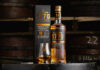 Glasgow 1770 unveils first 10 Year Old peated malt A bottle of Glasgow 1770 10 Year Old Peated Single Malt Scotch Whisky stands on a barrel with its outer packaging next to it with a nosing glass with the whisky inside.
