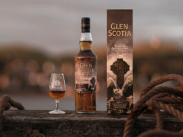 Glen Scotia unveils latest Campbeltown series whisky A bottle of Glen Scotia Icons of Campbeltown No.4 stands on a barrel on a dock with the outer case next to it and a nosing glass on its other side with the whisky inside.