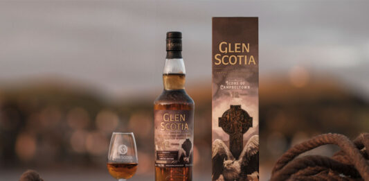 Glen Scotia unveils latest Campbeltown series whisky A bottle of Glen Scotia Icons of Campbeltown No.4 stands on a barrel on a dock with the outer case next to it and a nosing glass on its other side with the whisky inside.