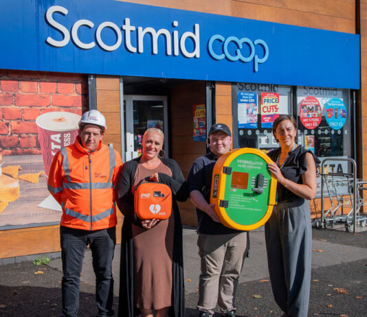 Taylor Wimpey donates defibrillator to Scotmid A group of people stand outside Scotmid Ratho Station holding a defibrillator device that is to be installed on the store's exterior wall.
