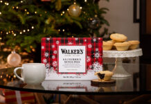 Walker’s sets out Christmas range for 2026 A pack of Walker's Luxury Mince Pies sits on a table with a mug next to it and one of the mince pies to the other side of it. In the background, the pies are stacked up on a table and there is a Christmas tree.