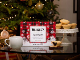 Walker’s sets out Christmas range for 2026 A pack of Walker's Luxury Mince Pies sits on a table with a mug next to it and one of the mince pies to the other side of it. In the background, the pies are stacked up on a table and there is a Christmas tree.