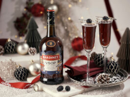 Bardinet rolls out limited edition design for Christmas A bottle of Bardinet VSOP stands on a table with two cocktail serves next to it. There is a range of Christmas decorations across the table as well.