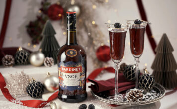 Bardinet rolls out limited edition design for Christmas A bottle of Bardinet VSOP stands on a table with two cocktail serves next to it. There is a range of Christmas decorations across the table as well.