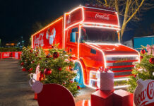 Vote opens for Coca-Cola Christmas truck’s next stop The Coca-Cola Christmas Truck is parked up with lighting around its edges and decorative Coca-Cola branded Christmas decorations around it.
