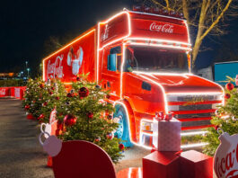Vote opens for Coca-Cola Christmas truck’s next stop The Coca-Cola Christmas Truck is parked up with lighting around its edges and decorative Coca-Cola branded Christmas decorations around it.