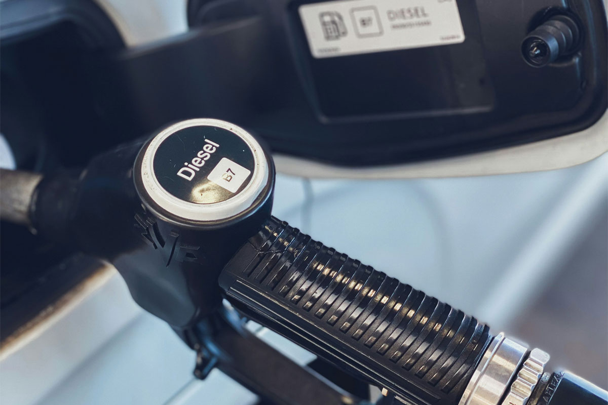 A diesel pump sits inside a car filling up the tank.