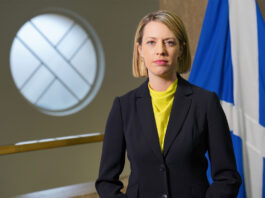 Industry calls on ScotGov to act before rates soar out of control Jenny Gilruth, deputy First Minister of the Scottish Government, stands in Parliament with the Scotland flag behind her.