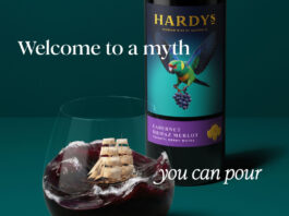 Hardys wine unveils complete brand refresh Promotional image of the new Hardys wine redesign with a bottle of the wine in the background with a glass of red wine poured in front of it. The wine inside mimics a stormy sea with a ship in the tides. The text around the two reads 'Welcome to a myth you can pour'.