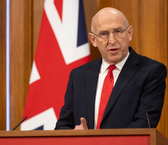 Budget aims to offer ‘breathing space’ for businesses John Healey, Chancellor of the Exchequer, stands at a podium delivering a speech with the UK flag behind him.