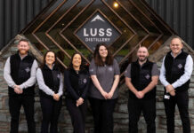 Luss Distillery marks first anniversary Team members from the Luss Distillery stand outside the building with the Luss Distillery logo behind them.