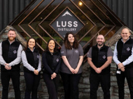 Luss Distillery marks first anniversary Team members from the Luss Distillery stand outside the building with the Luss Distillery logo behind them.