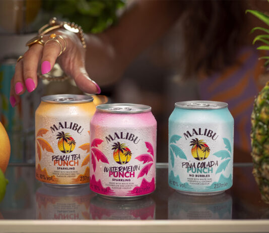 Malibu doubles down on RTDs with new Malibu Punch range Cans of Malibu Punch sit on a bar as a person's hand reaches for them. There is also different pieces of fruit across the bar.