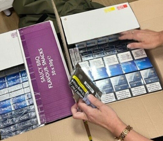 Scottish Illicit Tobacco Team seizes over half a million cigarettes Boxes filled with illicit cigarettes as a person examines the contents inside.
