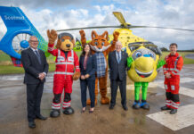Scotmid partnership with Air Ambulance takes off Scotmid Co-op representatives and members of Scotland's Charity Air Ambulance stand on a heliport with their respective mascots and a helicopter behind them.
