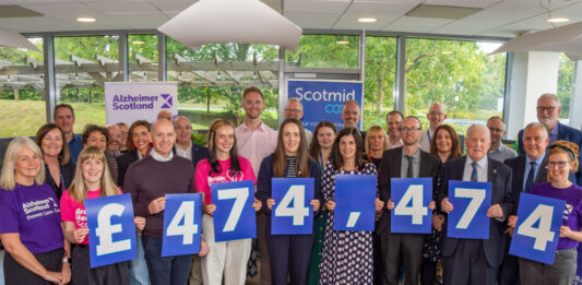Scotmid marks landmark fundraising for Alzheimer charities Members of the Scotmid Co-op and Alzheimer Scotland teams stand together holding signs that read £474,474 to highlight the fundraising the retail chain has made for the charity.