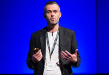Snappy Group receives seven figure investment from Virgin Money Barry McGonagle, chief financial officer at Snappy Group, stands on a stage with a blue backdrop delivering a talk.