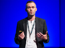 Snappy Group receives seven figure investment from Virgin Money Barry McGonagle, chief financial officer at Snappy Group, stands on a stage with a blue backdrop delivering a talk.